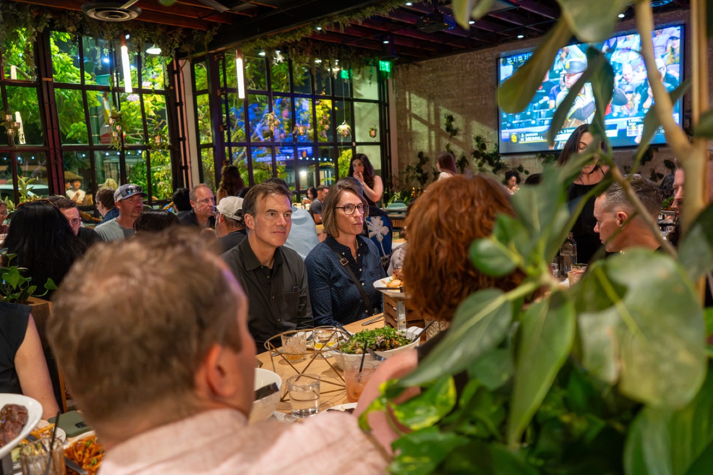 One long table under a glass roof at a past DDX dinner